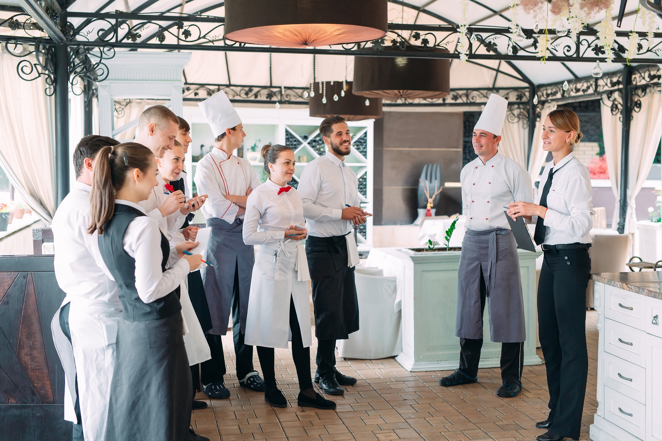 Restaurant manager and his staff in terrace. interacting to head chef in restaurant.
